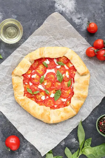 Lezzetli domates galeti ve gri arka planda fesleğen içeren kağıt fırını.