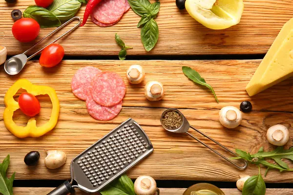 Tahta arka planda pizza hazırlamak için gerekli malzemeler