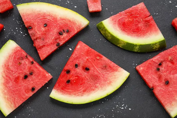 Koyu arkaplanda olgun karpuz parçaları olan kompozisyon, yakın plan.