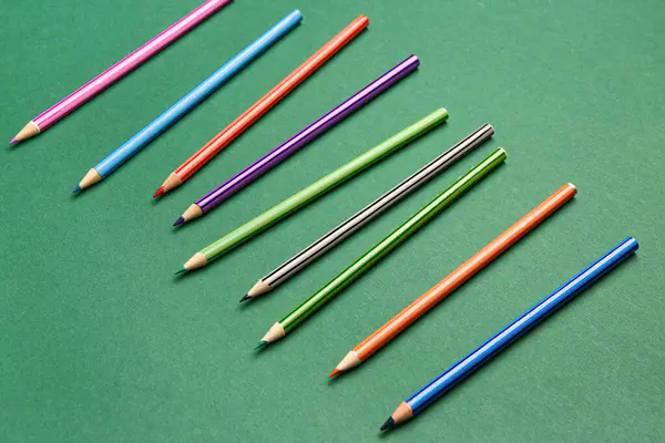 Yeşil karatahta üzerinde renkli kalemler grubu