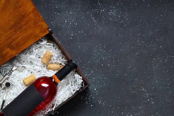 Siyah grunge arka planda şarap ve mantar dolu bir kutu.