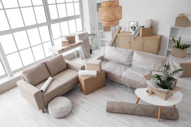 Taşındığı gün kanepeleri ve karton kutuları olan oturma odasının içinde.