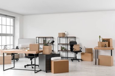 Taşınma gününde işyeri, raf üniteleri ve karton kutular ile ofis içi