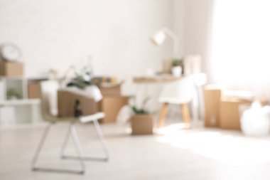 Taşındığı gün masa, sandalye ve karton kutularla ofisin bulanık görünümü