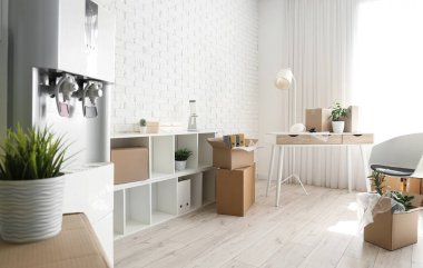 Taşındığı gün ofisinde karton kutular olan çalışma yeri ve raf ünitesi