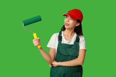 Yeşil arka planda yuvarlanan Asyalı kadın ressam