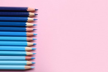 Pembe arka planda mavi kalemler, yakın plan.