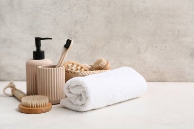 Banyodaki grunge duvarının yanında temiz havlu ve banyo malzemeleri.