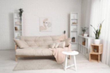 Güzel bir oturma odası, rahat bir kanepe, raflar ve kahve masası, bulanık bir manzara.