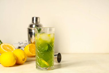 Limonlu bir bardak limonata ve beyaz arka planda nane şekeri.