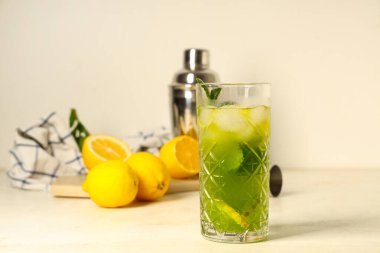 Limonlu bir bardak limonata ve beyaz arka planda nane şekeri.