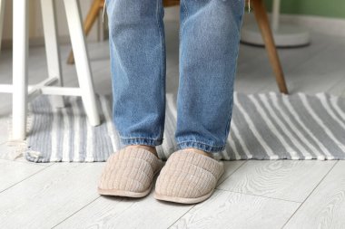 Kadın bacakları şık terliklerle odada, yakın plan.