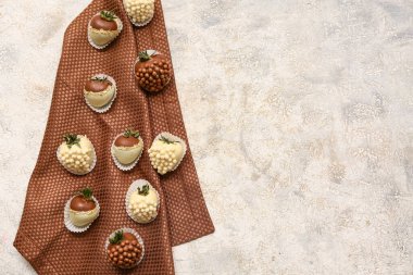 Gri arka planda çikolata kaplı çilekler.