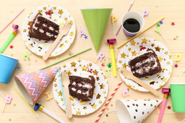 Lezzetli doğum günü pastası tabakları ve ahşap arka planda doğum günü partisi için dekorasyon.