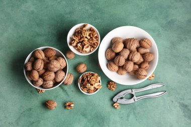 Lezzetli cevizli kaseler ve yeşil arka planda fındıkkıran