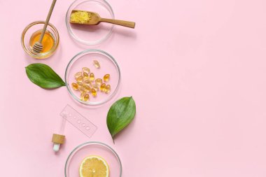 Pembe arka planda doğal kozmetik ürünleri hazırlamak için numune ve malzeme içeren petri kapları