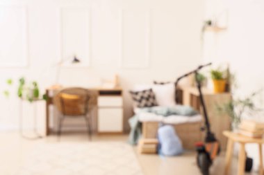 Yatağı, çalışma masası ve scooter 'ı olan aydınlık çocuk odasını bulanık görmek