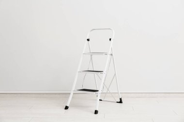 Bakım merdiveni beyaz duvarın yanında