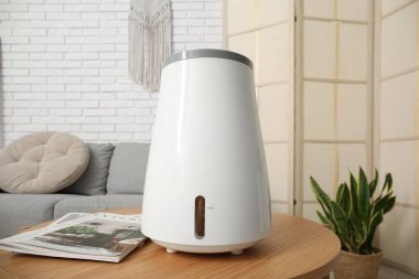 Oturma odasındaki masasında dergiler olan hava nemlendirici.