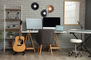 Çalışma yeri, raf ünitesi ve müzik aletleriyle kayıt stüdyosunun içi