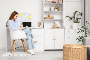 Ofisteki masada genç bir kadın yapılacaklar listesi yapıyor.