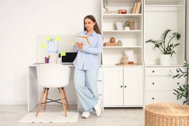 Genç bir kadın merkez ofiste yapılacaklar listesi yapıyor.