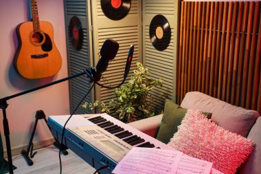 Kanepe ve müzik aletleriyle birlikte karanlık kayıt stüdyosunun içi