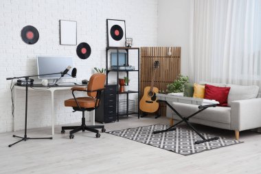 Çalışma yeri, müzik aletleri ve kanepesi olan kayıt stüdyosunun içi