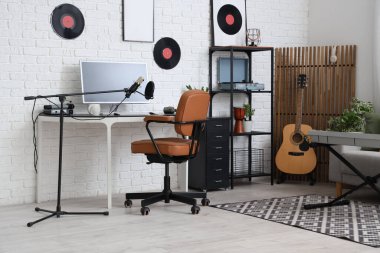 Interior of recording studio with workplace, shelf unit and musical instruments
