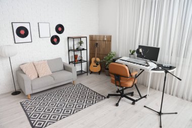 Çalışma yeri, müzik aletleri ve kanepesi olan kayıt stüdyosunun içi