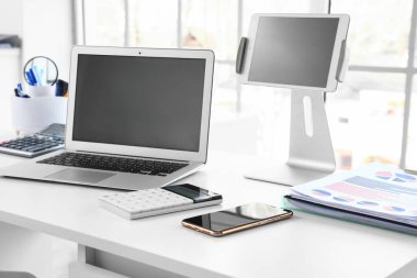 Ofisteki muhasebecinin masasında tablet bilgisayarı olan boş bir dizüstü bilgisayar.