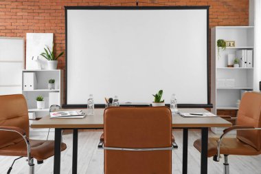 Projektör ekran, raf üniteleri ve tablo ile konferans salonunun içi