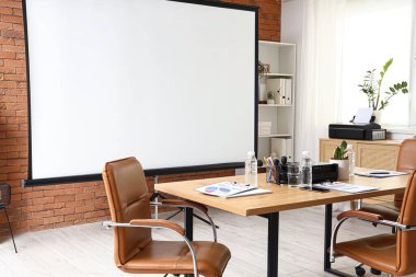 Projektör ekranlı, raf üniteli ve masalı konferans salonunun içi