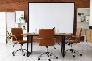 Projektör ekran, raf üniteleri ve tablo ile konferans salonunun içi