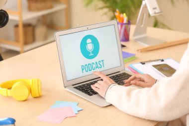 Stüdyoda dizüstü bilgisayar kullanan kadın podcaster, yakın plan.