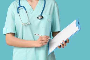 Steteskop ve mavi arka planda panosu olan bir kadın kardiyolog.