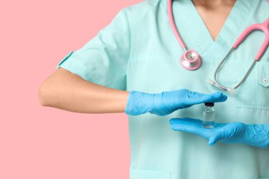 Pembe arka planda steteskop ve ampul kullanan kadın kardiyolog, yakın plan.