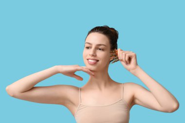 Mavi arka planda ampulleri olan gülümseyen genç bir kadın.