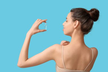 Mavi arka planda ampulü olan genç bir kadın.