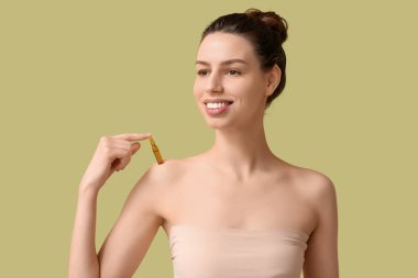 Yeşil arka planda ampulü olan mutlu genç bir kadın.