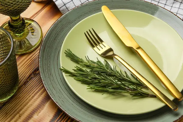 Ahşap zemin üzerinde çatal bıçak ve biberiye ile modern masa ayarları