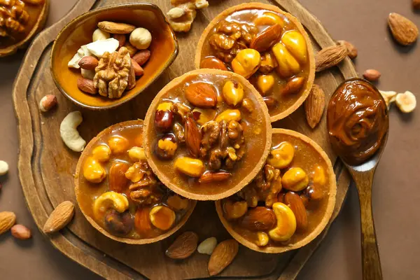 Fındıklı turtalar ve tahtanın üzerinde kahverengi arka planda karamel.