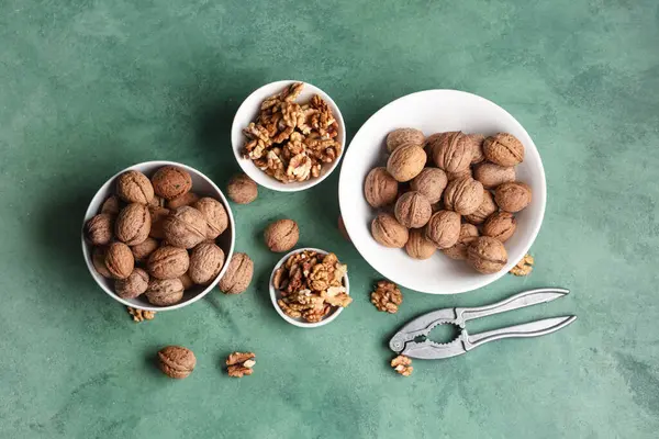 Lezzetli cevizli kaseler ve yeşil arka planda fındıkkıran