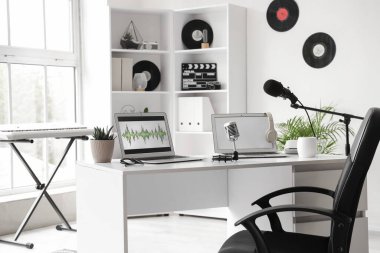 İş yeri, raf ünitesi ve sentezleyicili Podcaster 'ın stüdyosunun içi