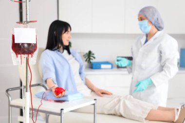 Kadın donöre kan nakli için kan paketi. Klinikte doktor var. Yakın plan.