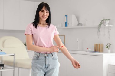 Klinikte kan bağışından sonra tıbbi bandı olan genç bir kadın.