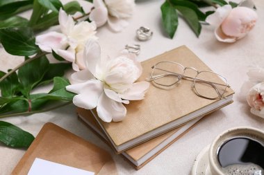 Bej rengi grunge arka planda kitaplar, gözlük ve şakayık çiçekleri olan kompozisyon, yakın plan