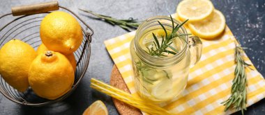 Mason kavanozu biberiyeli taze limonata ve mavi arka planda limonlar, yakın plan.