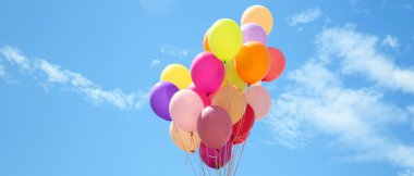 Mavi bulutlu gökyüzüne karşı bir sürü renkli balon
