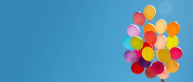 Mavi gökyüzüne karşı bir sürü renkli balon. Tasarım için pankart